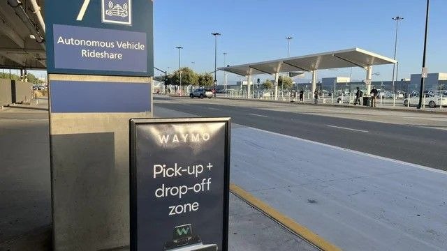 Un Waymo se marcha del aeropuerto con el equipaje de un pasajero en el maletero